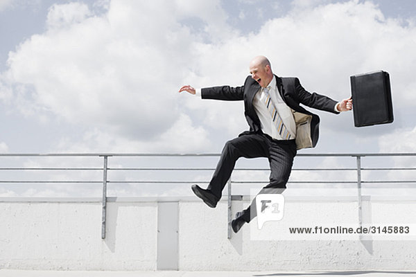 man jumping in the air with briefcase
