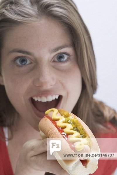 Frau beim Hot Dog mit Senf essen