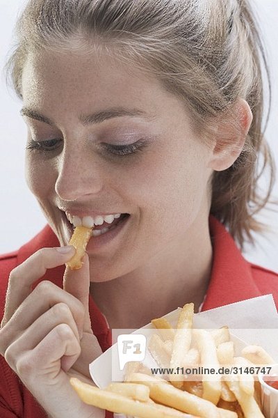 Young woman eating a bag of chips