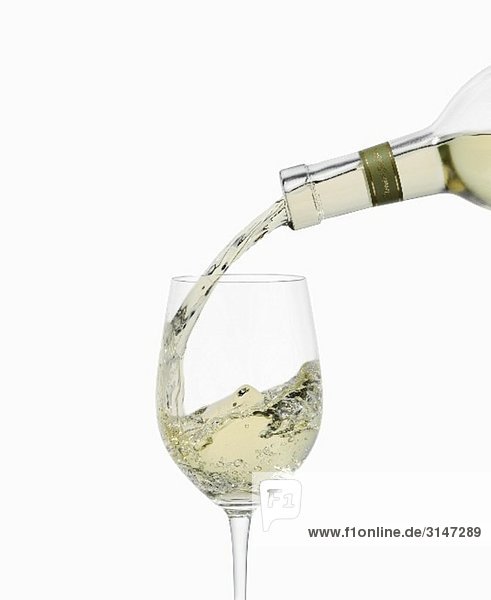 Ein Glas Weisswein eingießen
