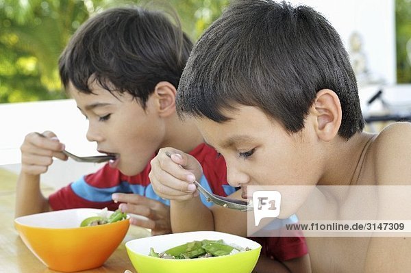 Two children eating soup