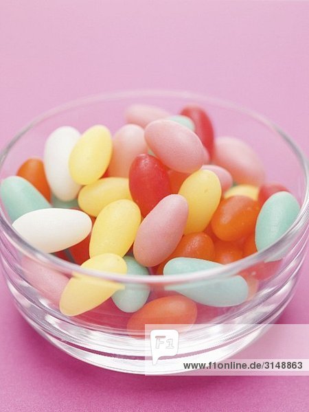 Bunte Zuckereier in Glasschale  pinkfarbener Hintergrund
