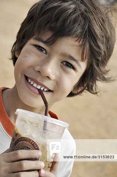 Smiling boy drinking iced cocoa