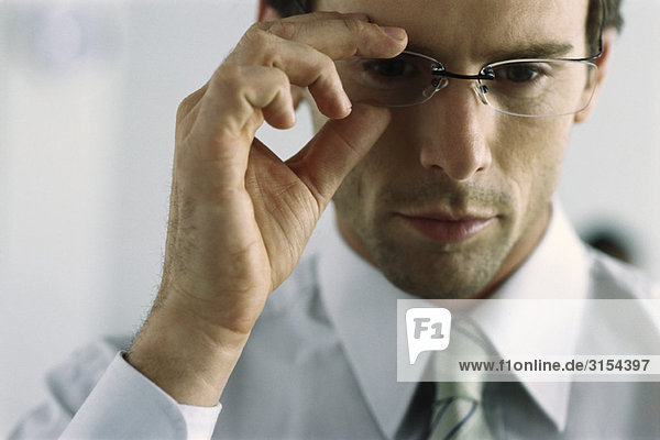 Young businessman adjusting glasses  portrait