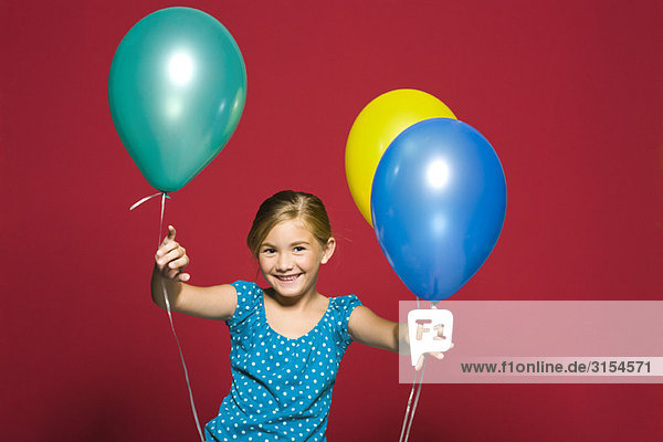 Mädchen stehend mit Luftballons  lächelnd  Portrait