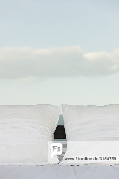 Kissen auf dem Bett  Wolken im Hintergrund