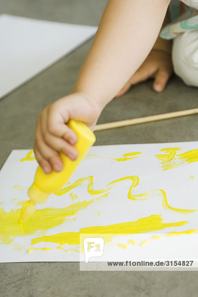 Kind drückt Farbe auf Papier  abgeschnitten