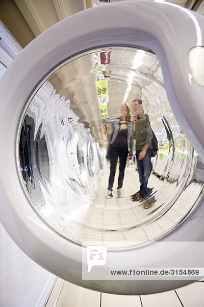Shoppers seen through open washing machine door