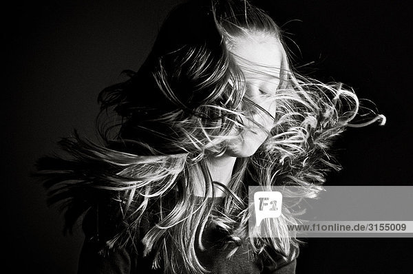 Black and white of a young girl with her hair in motion around her face