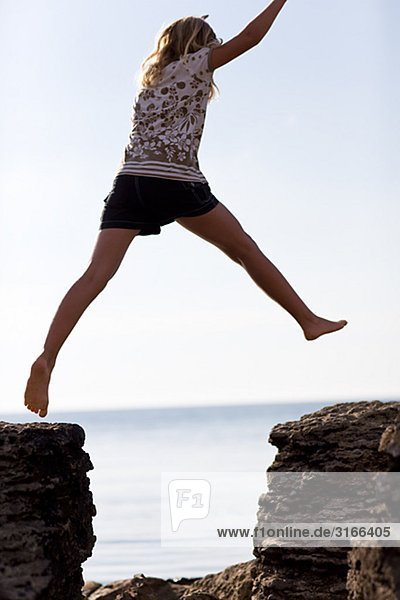 Ein Mädchen springen auf Felsen Schweden.