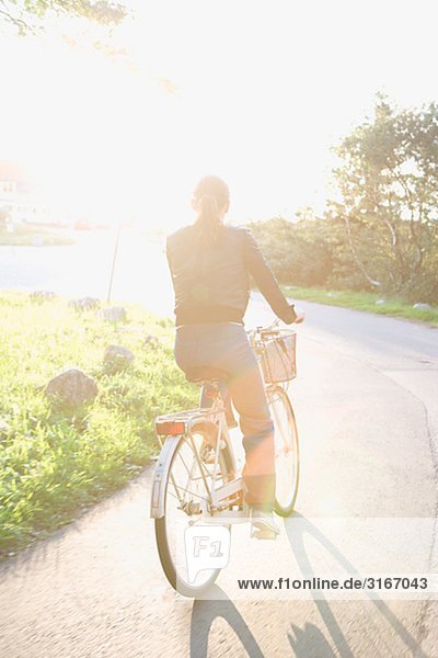 Frau mit dem Fahrrad gegen das Licht  Schweden.