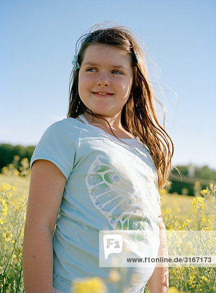 Ein glückliches Mädchen in einem Feld von blühenden Raps  Schweden.
