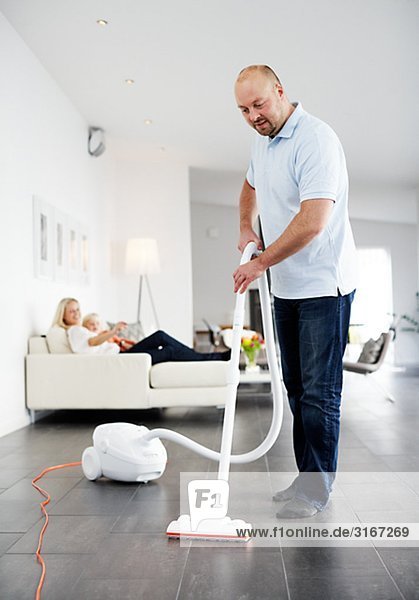A man vacuuming a floor Sweden.