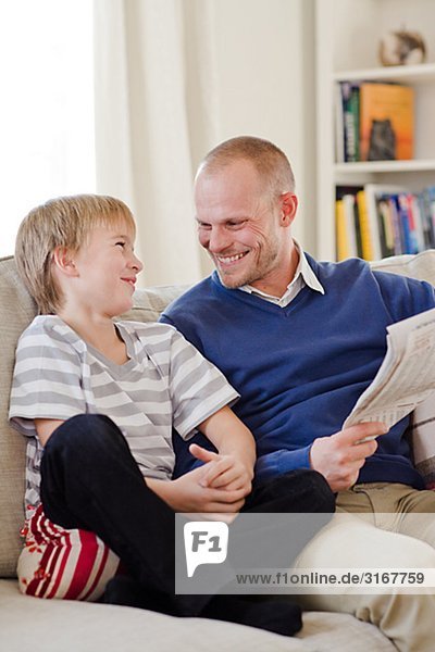 Vater und Sohn Lesen der Zeitung  Schweden.