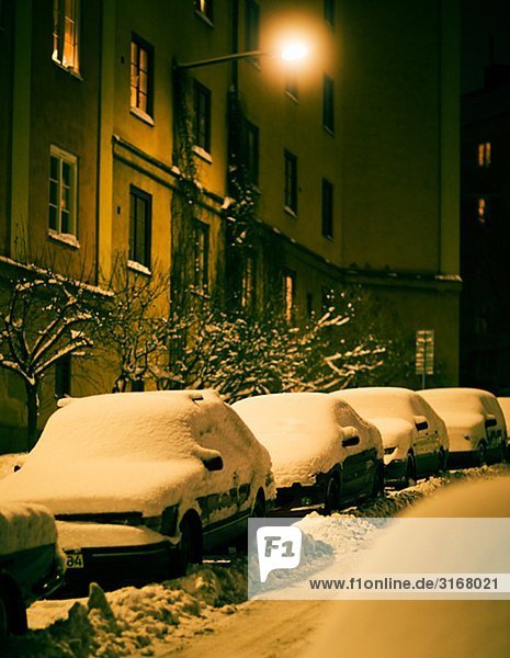 Snow-covered cars on a street  Sweden.