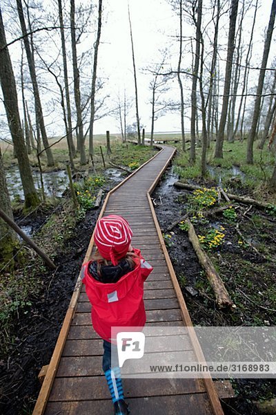 Ein kleines Mädchen zu Fuß in einer Gesamtstruktur Schweden.