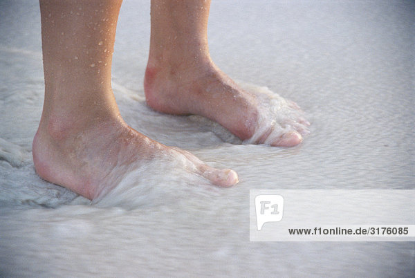 Nackte Füße am Strand.