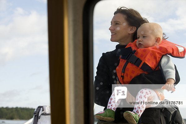 A woman carrying a child on a boat  Sweden.