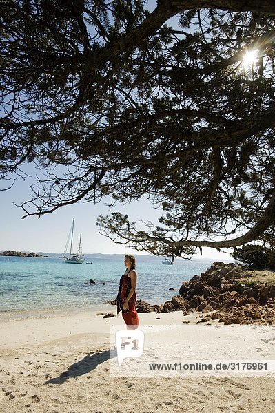 A woman standing on a beach  Sardinia  Italy.