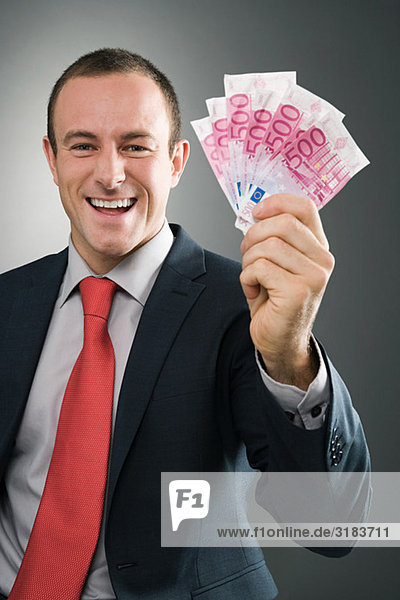 Lächelnder Geschäftsmann mit Banknoten
