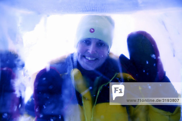 Eine Frau fotografiert durch einen Block von Eis  Schweden.