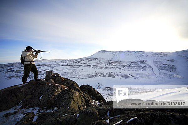 A hunter on a grouse-shooting expedition in the north of Sweden.