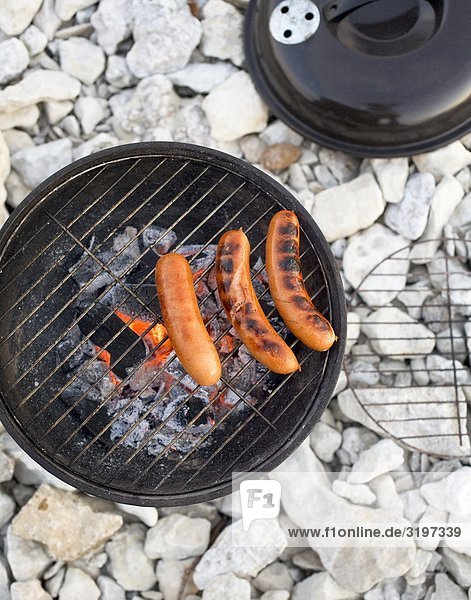Sausages on a grill on the beach,  Sweden.
