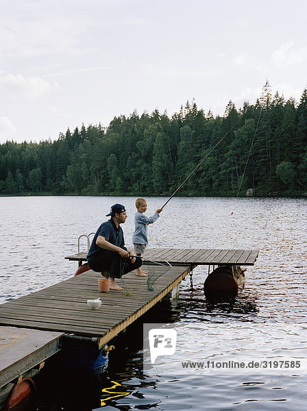 sitzend Menschlicher Vater Sohn Steg angeln Schweden