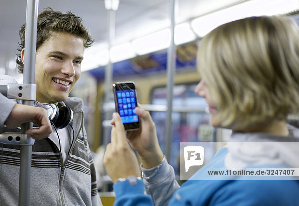 Junger Mann wird in U-Bahn mit Mobiltelefon fotografiert