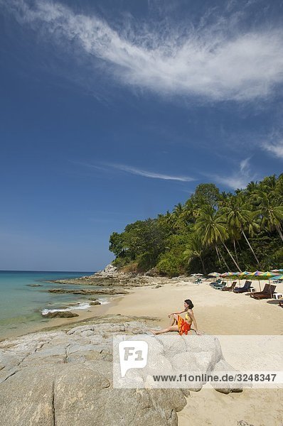 Frau sitzt auf Felsen  Surin Beach  Phuket  Thailand