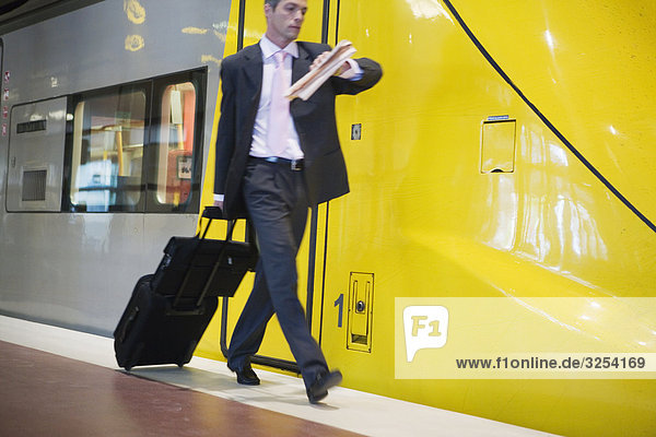 Geschäftsmann zu Fuß auf einer Plattform neben einem Zug Stockholm Schweden.