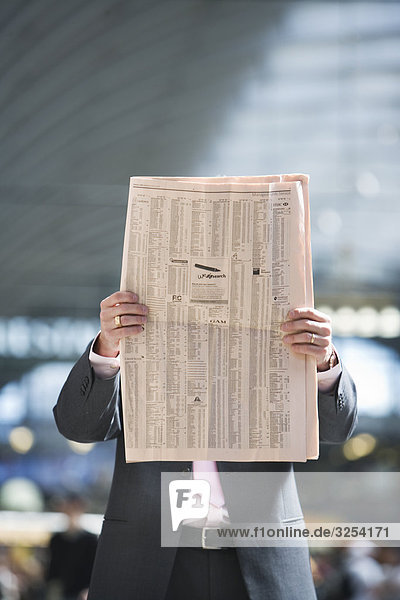 Ein Geschäftsmann lesen eine Zeitung Stockholm Schweden.