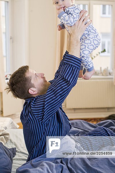 Vater mit seiner Tochter in einem Bett  Schweden.