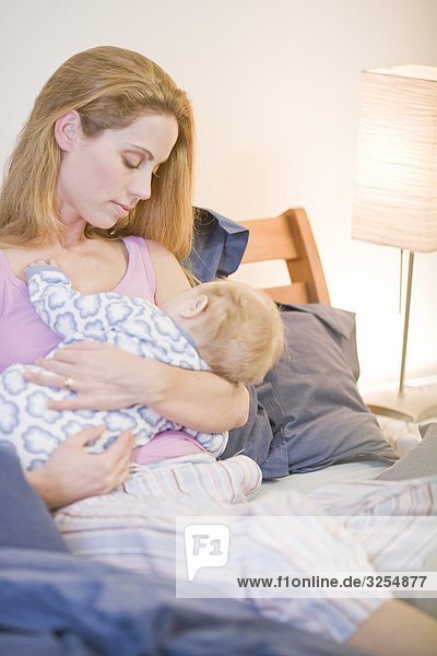 Mutter mit ihrem Baby in einem Bett  Schweden.