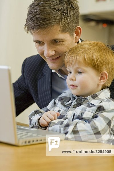 Father and son using a laptop  Sweden.
