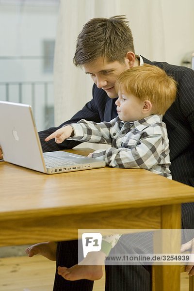 Vater und Sohn mit einem Laptop  Schweden.