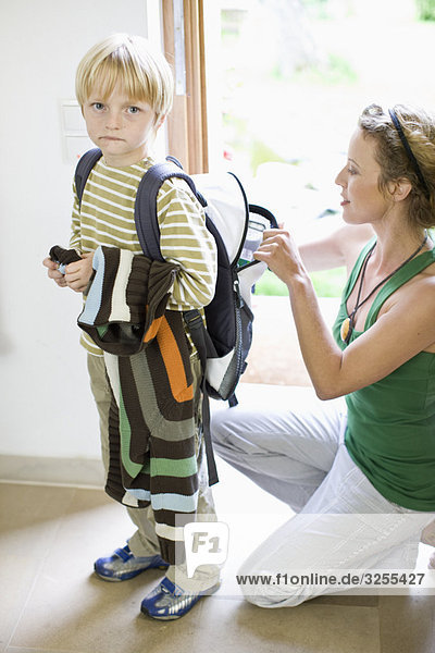 mother getting her son ready for school