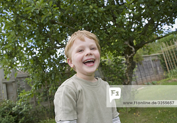 Junge lacht im Garten