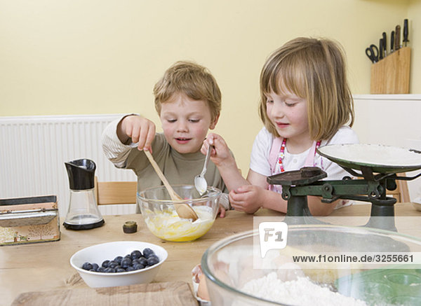 boy and girl making fruit muffins