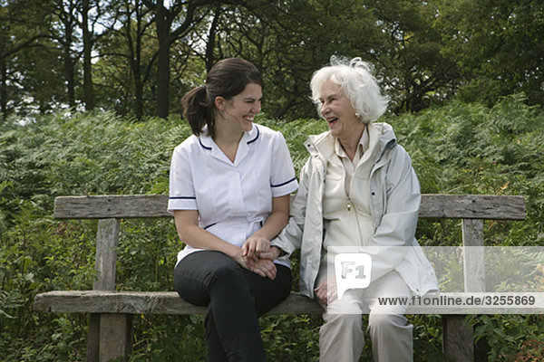 Nurse holding hand of elderly woman