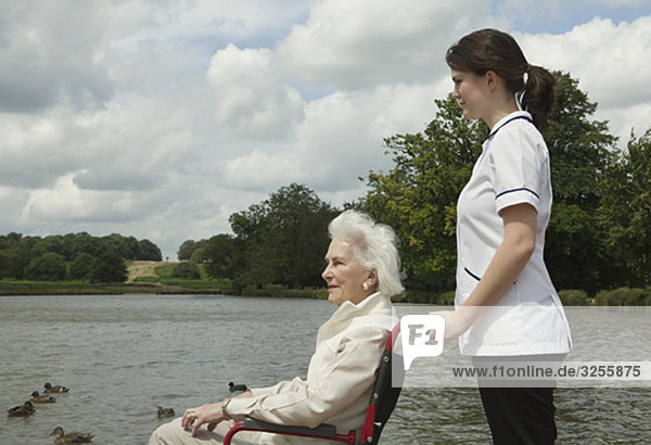 Ältere Frau im Rollstuhl mit Krankenschwester