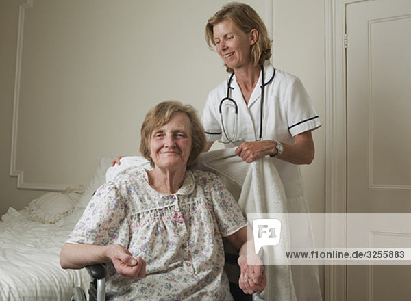 Nurse assisting elderly woman