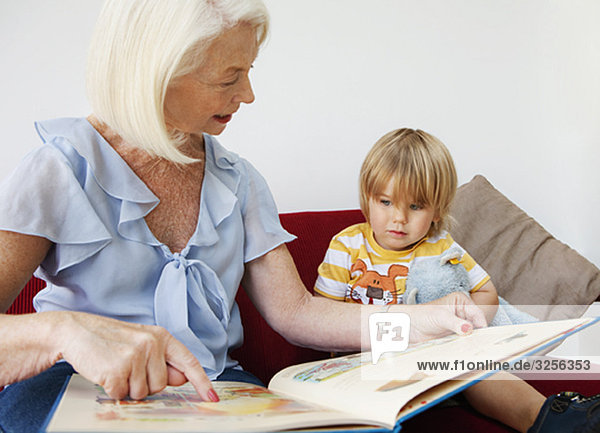 Eine Großmutter liest ihrem Enkel vor.