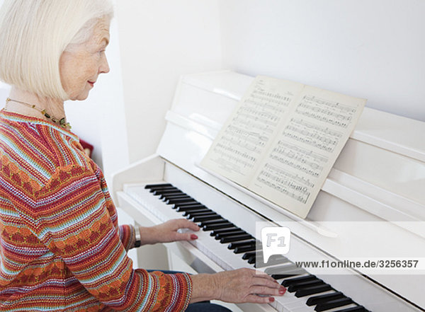 A senior female playing the piano