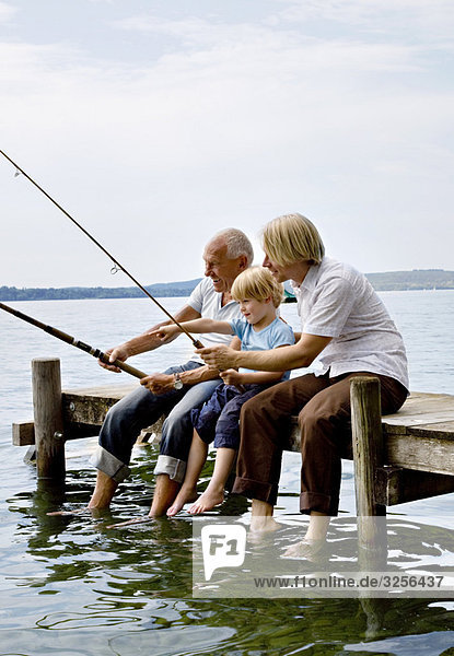 boy fishing with grandfather  father