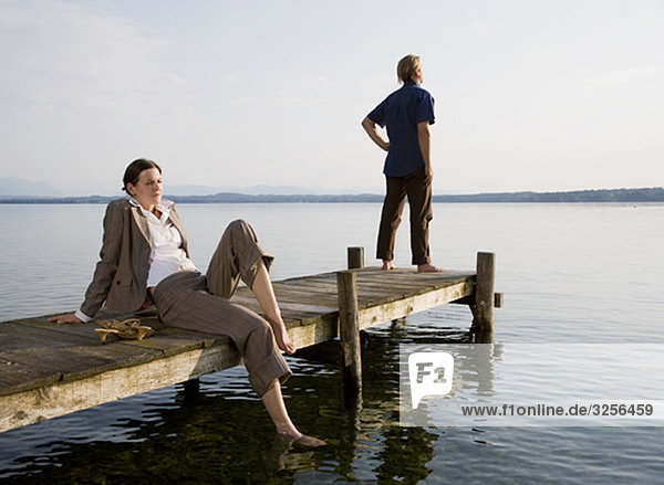 woman and man on pier at lake