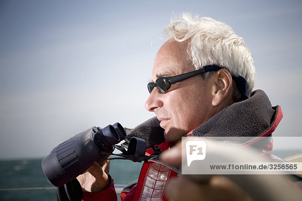 Man with binoculars sailing