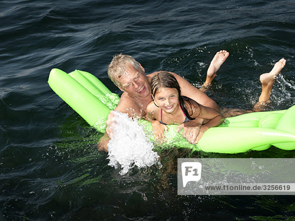 Großvater spielt mit Mädchen im Wasser