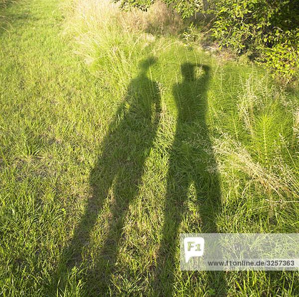 Schatten von zwei Personen auf Gras