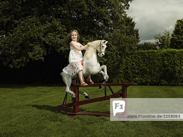 A young girl on a rocking horse
